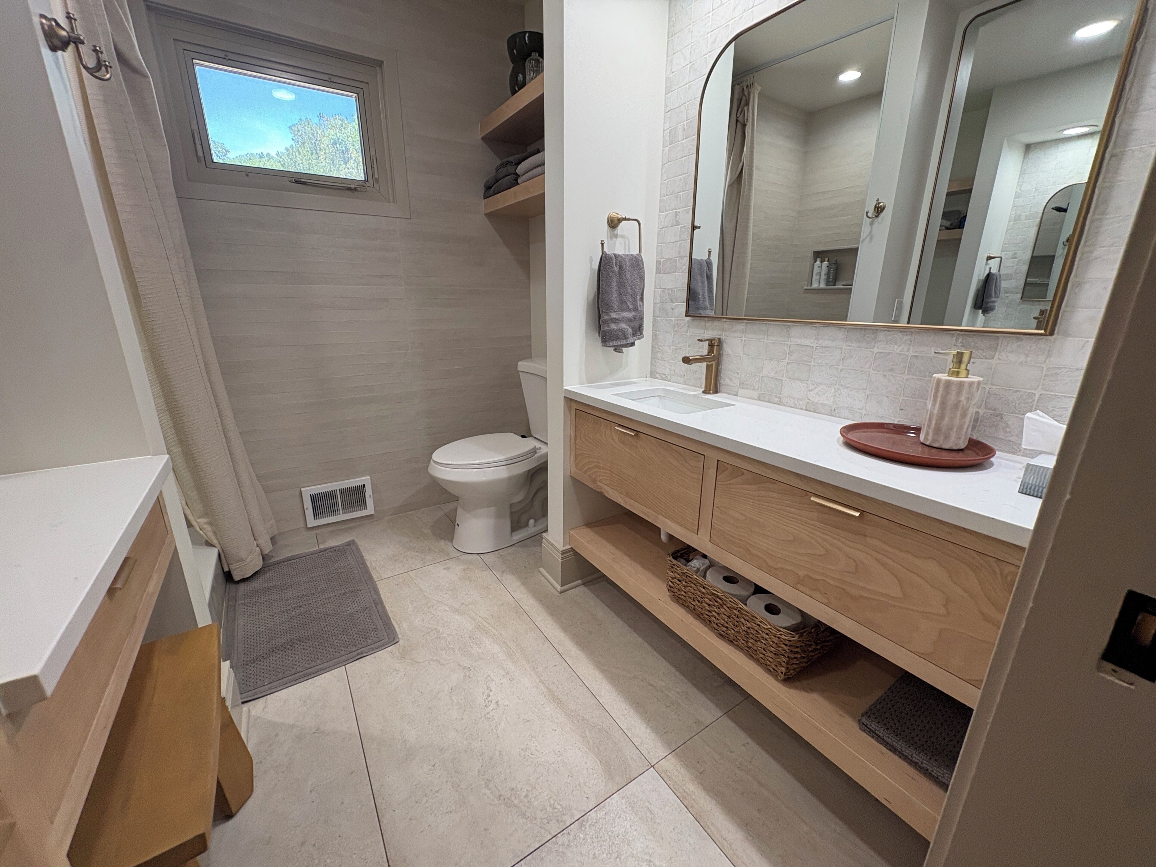 A modern bathroom with a toilet, sink, and mirror.