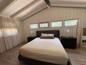 A bedroom with a large bed, two bedside tables, and three windows. - Spacious Ranch on Large Lot W Ample Parking (Wichita)