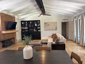 A modern living room with a fireplace, a sofa, a coffee table, and a bookshelf. - Spacious Ranch on Large Lot W Ample Parking (Wichita)