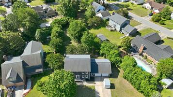 A residential area with houses, a swimming pool, and green lawns.