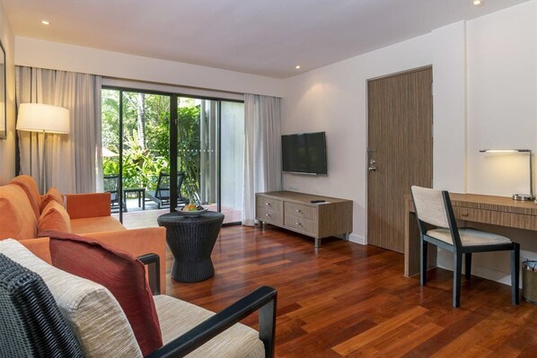 Una sala de estar moderna con un sofá, una mesa de centro, un televisor y una zona de trabajo.