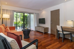 Ein modernes Wohnzimmer mit einer Couch, einem Couchtisch, einem Fernseher und einem Schreibtisch mit Stuhl.