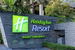 Indicador de Holiday Inn Resort Phuket Surin Beach amb un disseny modern i vegetació als voltants.