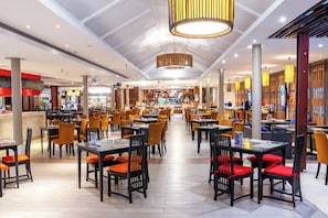 A spacious restaurant with multiple dining areas, high ceilings, and modern lighting fixtures. - Holiday Inn Resort Phuket Surin Beach (Choeng Thale)