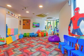 A brightly colored playroom with a patterned carpet, colorful chairs, and a large Spider-Man cutout. - Holiday Inn Resort Phuket Surin Beach (Choeng Thale)
