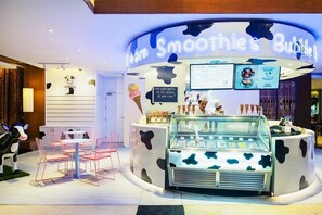 A dessert shop named 'Smoothies Bubble' with a cow-themed design, a menu board, and a seating area with chairs. - Holiday Inn Resort Phuket Surin Beach (Choeng Thale)