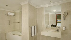 Een badkamer met een bad, een wastafel, een spiegel en een douche.