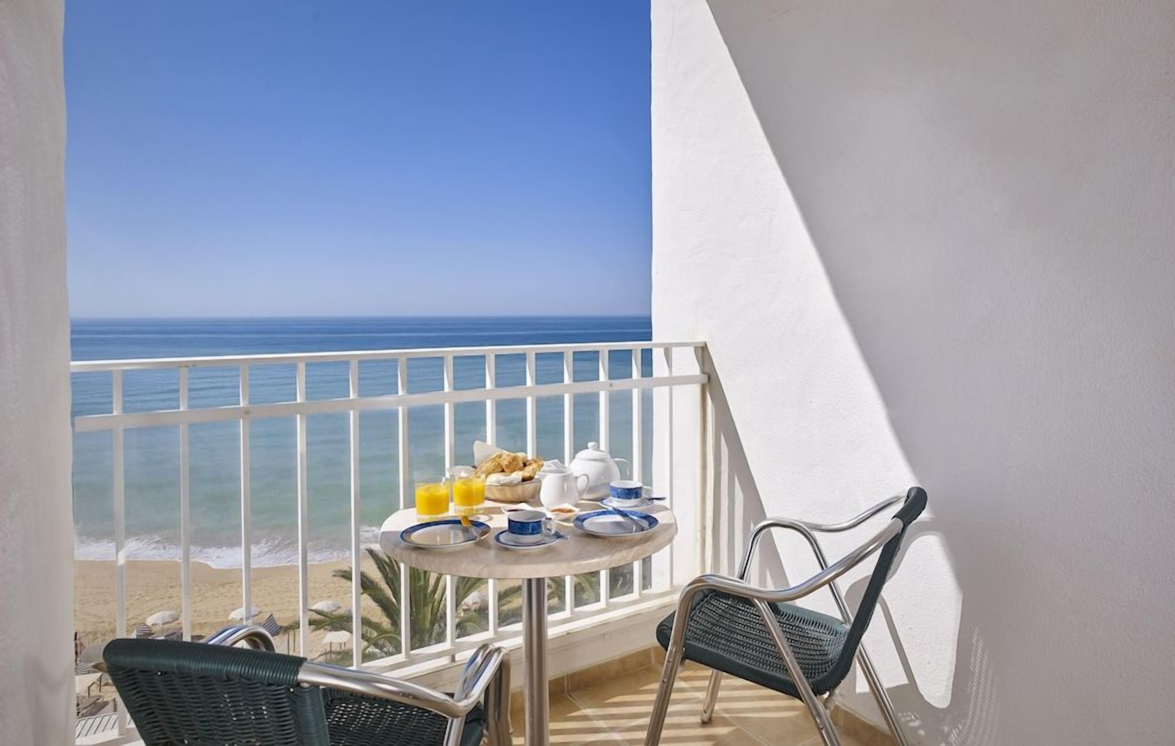 Un balcó amb taula preparat per esmorzar i vista a l'oceà.