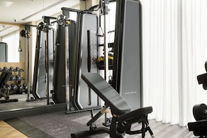 A gym with various exercise equipment, including weight machines and dumbbells.