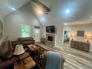 A spacious living room with a high ceiling, a fireplace, a television, and a cozy seating area. - Cozy 3BR/2BA with Mountain Vibes - 3 min from DT Clayton (Clayton)