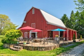 A red barn with a white roof, outdoor seating area with umbrellas, and a stone pathway leading to the entrance. - Cozy 3BR/2BA with Mountain Vibes - 3 min from DT Clayton (Clayton)