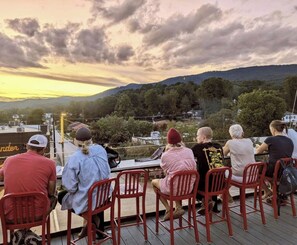 A group of people seated on red chairs on a wooden deck overlooking a landscape with trees and hills. - Cozy 3BR/2BA with Mountain Vibes - 3 min from DT Clayton (Clayton)