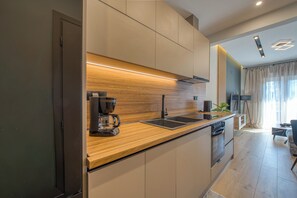 Une cuisine moderne équipée d’un four encastré, d’une machine à café et d’un évier.