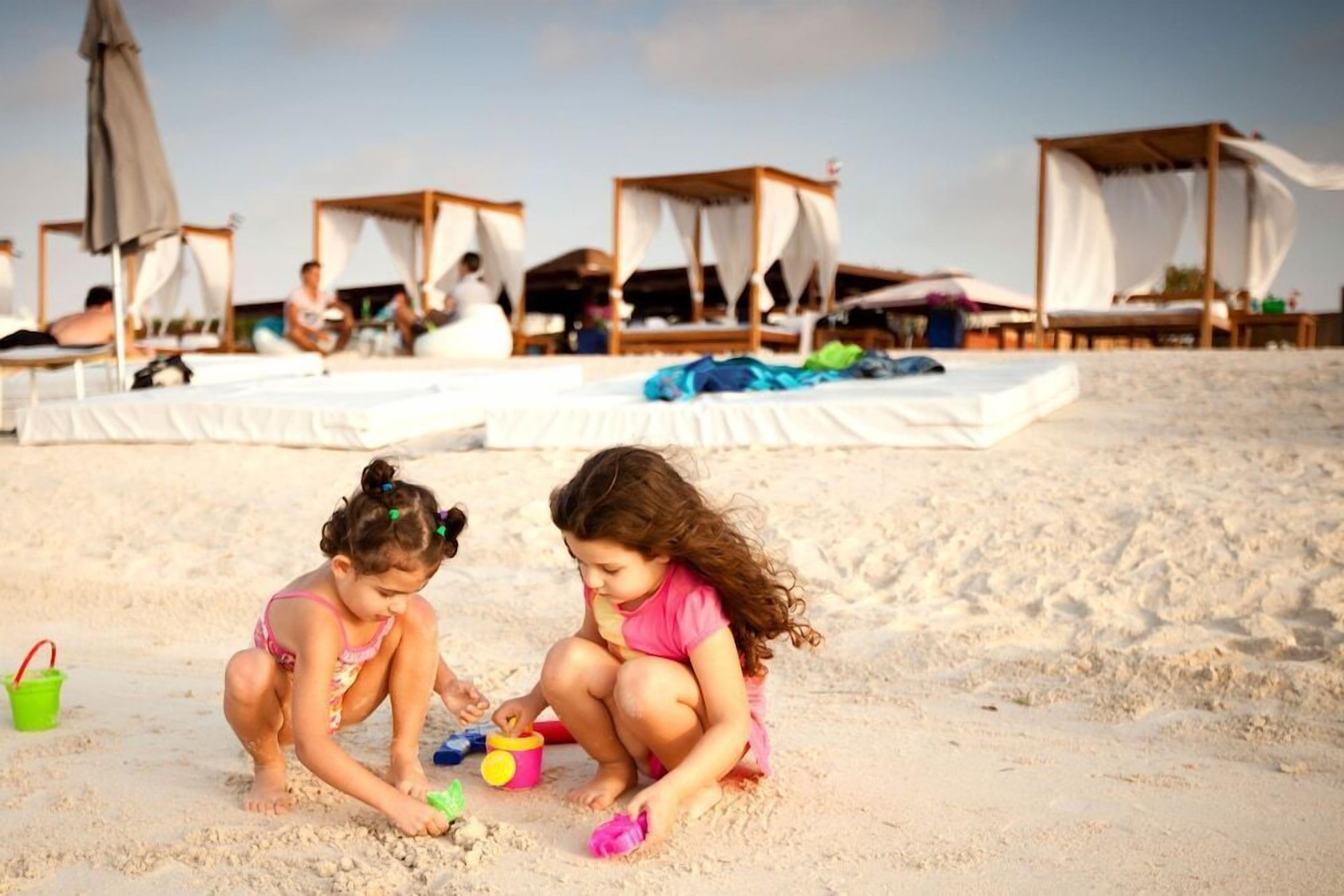 A beach with tents and people relaxing.