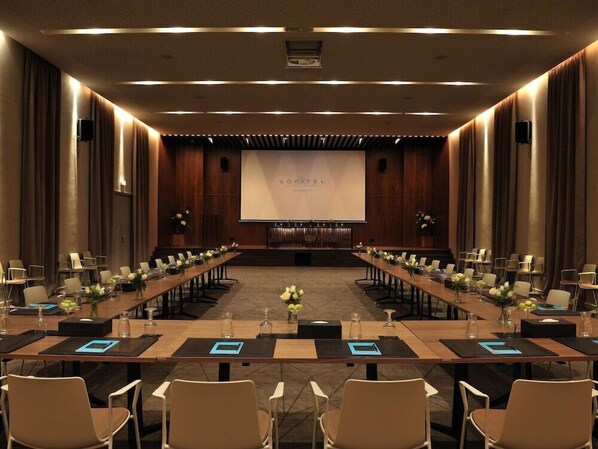 A conference room with a long table, chairs, and a screen displaying 'SOFITEL'. - Sofitel Marrakech Palais Imperial and Spa (Marrakech)