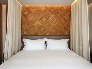 A hotel room with a bed, white curtains, a geometric patterned headboard, and two bedside lamps. - Sofitel Marrakech Palais Imperial and Spa (Marrakech)
