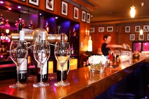 A bar area with a bartender preparing drinks, glasses, and bottles on the counter. - Sofitel Marrakech Palais Imperial and Spa (Marrakech)