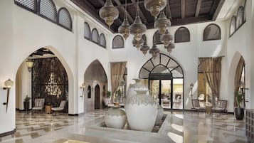 Un hall espacioso con techos altos, arcos ornamentales y faroles colgantes.