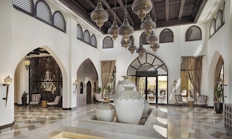 Un hall espacioso con techos altos, arcos ornamentales y faroles colgantes.