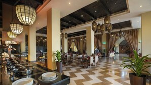 A hotel lobby with a buffet area, dining tables, and a check-in desk. - Aldhafra Resort, Vignette Collection, an IHG Hotel (Madinat Zayed)