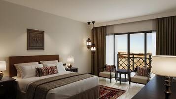 Habitación de hotel con una cama grande, un escritorio con una silla, un balcón con vistas al desierto y un adorno en la pared.