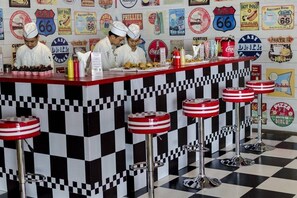 A diner with a checkered floor and red and white striped stools. - The Stones Hotel Legian Bali Autograph Collection (Legian)