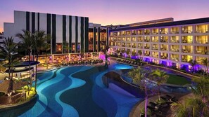 A hotel with a swimming pool, multiple floors, and a well-lit facade. - The Stones Hotel Legian Bali Autograph Collection (Legian)