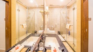 Ein Badezimmer mit einem großen Spiegel, zwei Waschbecken und einer Duschkabine.