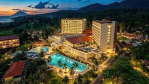 Ein Resort mit mehreren Gebäuden, einem Schwimmbad und einer Bergkulisse.