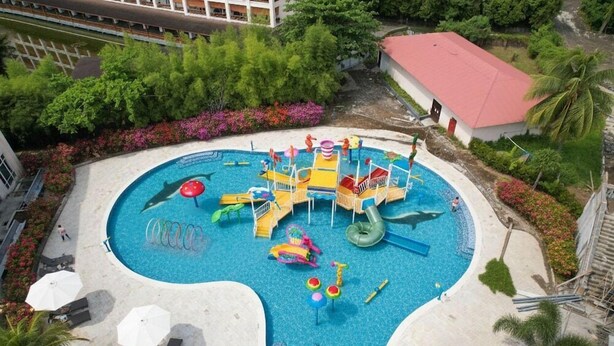 Ein Kinderspielbereich mit Pool, Rutschen und verschiedenen Spielgeräten.