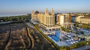 Un resort con varias edificaciones, un amplio espacio de piscina y vista al mar.