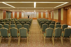 A conference room with rows of chairs, a podium, and a carpeted floor. - Taj Alibaug Resort & Spa, Maharashtra (Alibag)