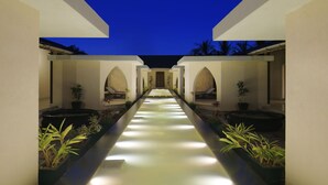 A corridor with a water feature, potted plants, and seating areas. - Taj Alibaug Resort & Spa, Maharashtra (Alibag)