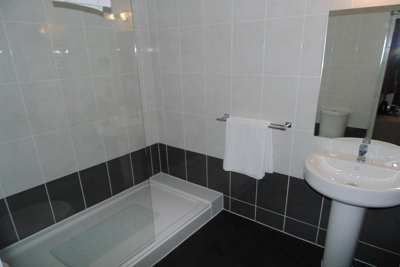 A bathroom with a bathtub, a sink, and a mirror.