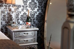 Un mini-bar contenant une bouteille de champagne et un verre.