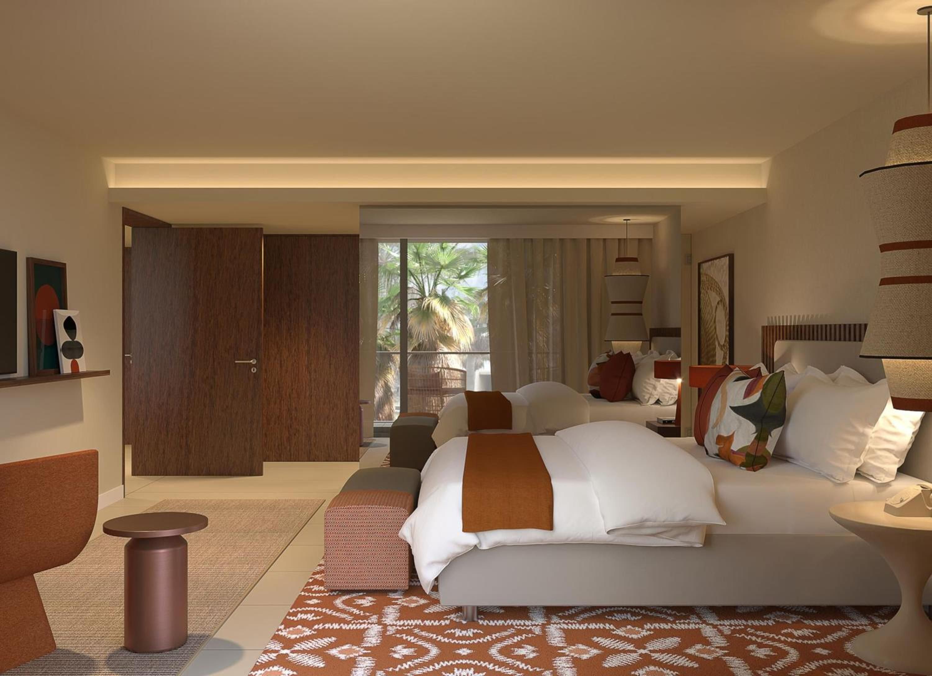 Een moderne hotelkamer met een groot bed, een zithoek, een kleintje tafeltje en uitzicht op palmbomen door het raam.