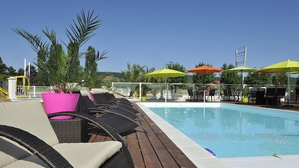 A poolside area with lounge chairs, umbrellas, and a clear view of the pool. - Brit Hotel Hermes (Couchey)