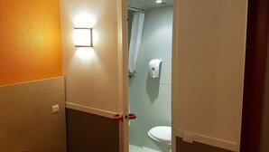 Un bagno con il water, un asciugamano elettrico e una tenda per la doccia.