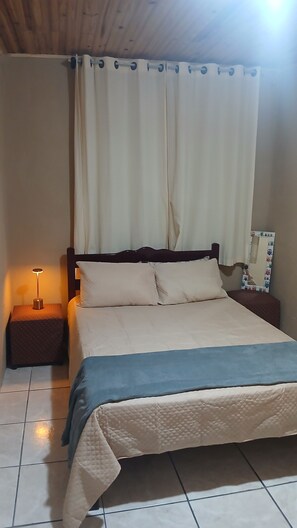 A bedroom with a bed, nightstands, a lamp, and a mirror. - Country house in a gated community with a private lake, accommodates up to 20 people. (Ibiúna)