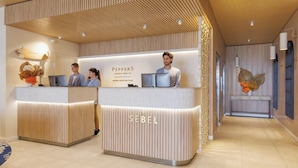Et receptionsområde med to diske, hvoraf den ene er mærket 'PEPPERS' og den anden 'SEBEL', begge med lodrette trælameller og moderne belysning.