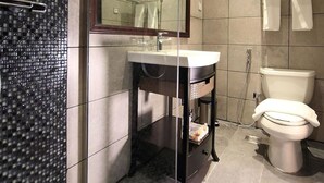 Un bagno moderno con cabina doccia in vetro, un mobile vanità con specchio e un water.