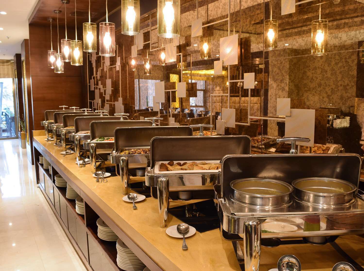 A buffet setup with multiple serving stations, each with a variety of food items and utensils.