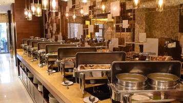 A buffet setup with multiple serving stations, each with a variety of food items and utensils.