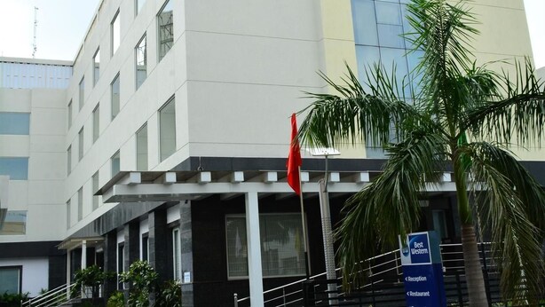 A modern building with a reception area, a flag, and a sign indicating amenities like a restaurant and board room. - Sagar Sona (Lucknow)