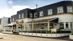 A two-story building with a flat roof, large windows, and a covered outdoor area with glass railings. - The White Sands Hotel Portmarnock (Portmarnock)