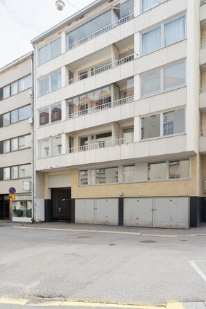 Monikerroksinen rakennus, jossa on autotalli alimmassa kerroksessa ja ylemmissä kerroksissa asuntoja.