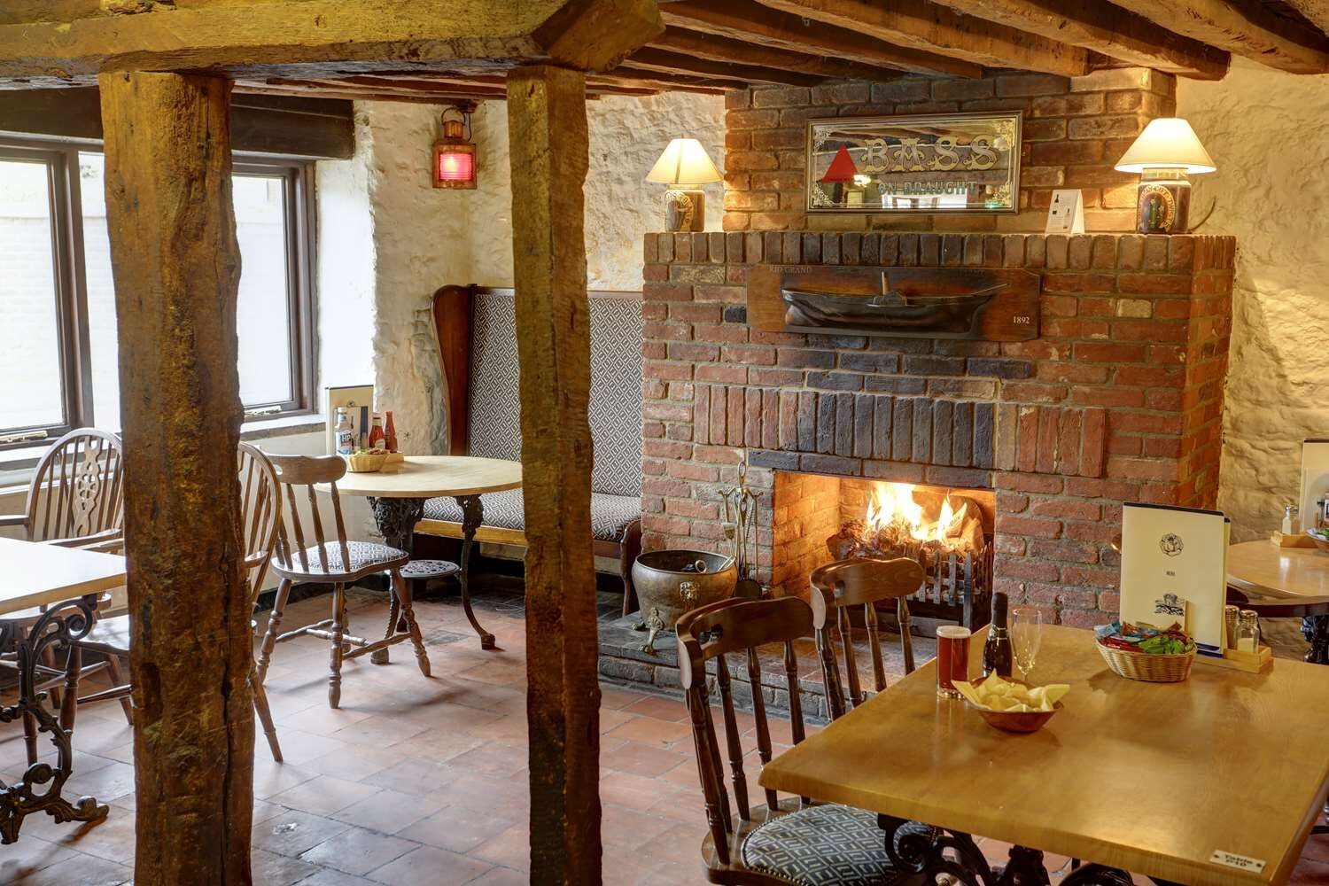 Un interior rústico con chimenea de ladrillo, muebles de madera y pared de piedra.