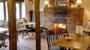 Un interior rústico con chimenea de ladrillo, muebles de madera y pared de piedra.
