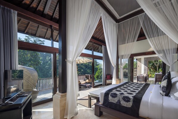 Un dormitorio con una cama grande, televisión y balcón con vistas al exterior.