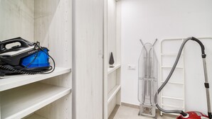A laundry room with a blue appliance, a metal drying rack, and a vacuum cleaner. - GRAN RESERVA MIMOSES ATIC B (Empuriabrava)